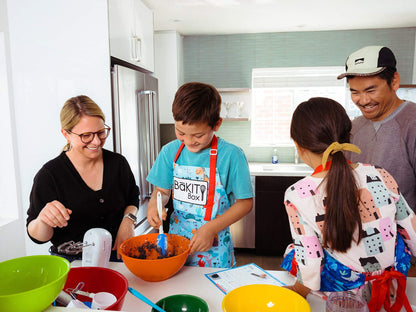 Family baking together with kids measuring ingredients in bowls